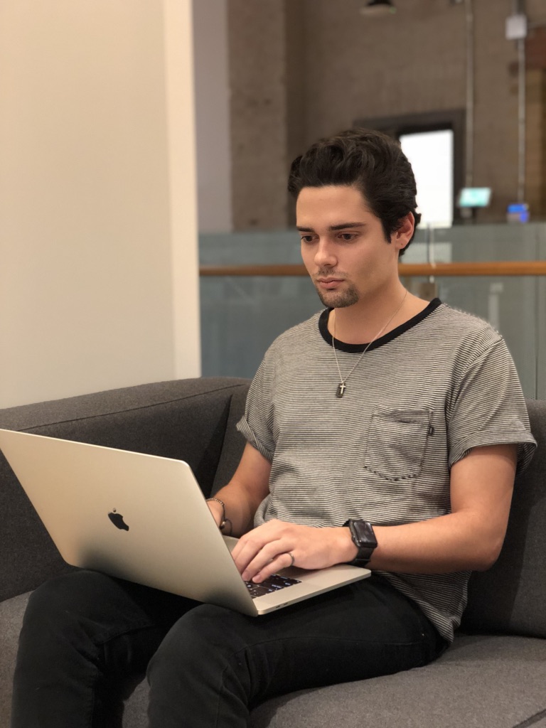 Spencer Canner working on a computer in a tech office.